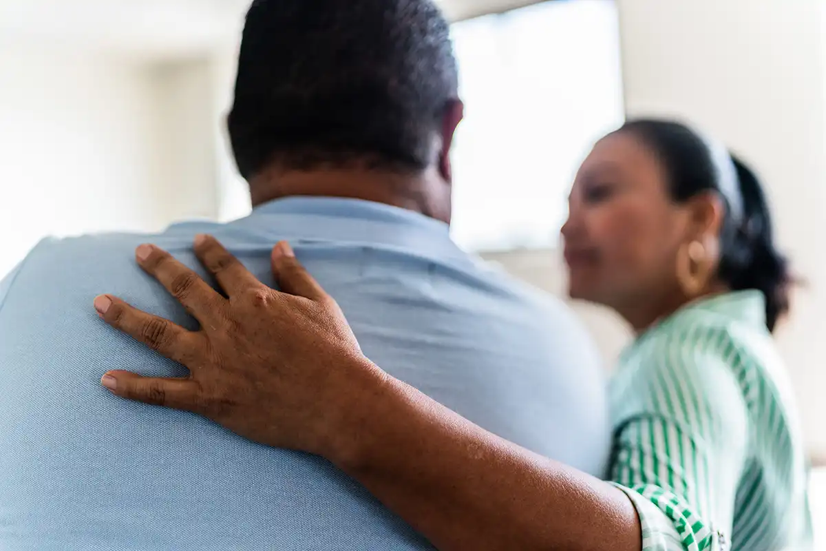 A supportive hand on a client's back during a session at Rock View Recovery